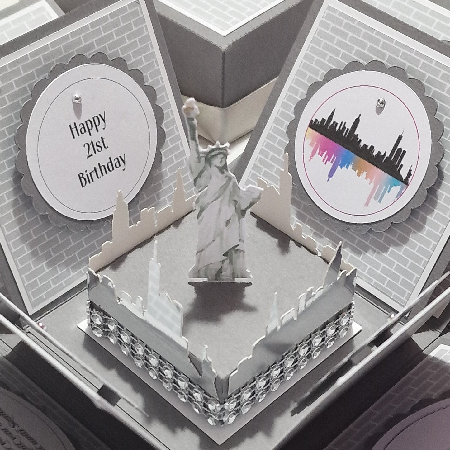 New York - Silver Grey Graffiti Styled - Surprise Special Occasion | Celebration Trip Reveal Explosion Box featuring New York elements, including a Statue of Liberty card and graffiti-style panels on a brick wall backdrop.