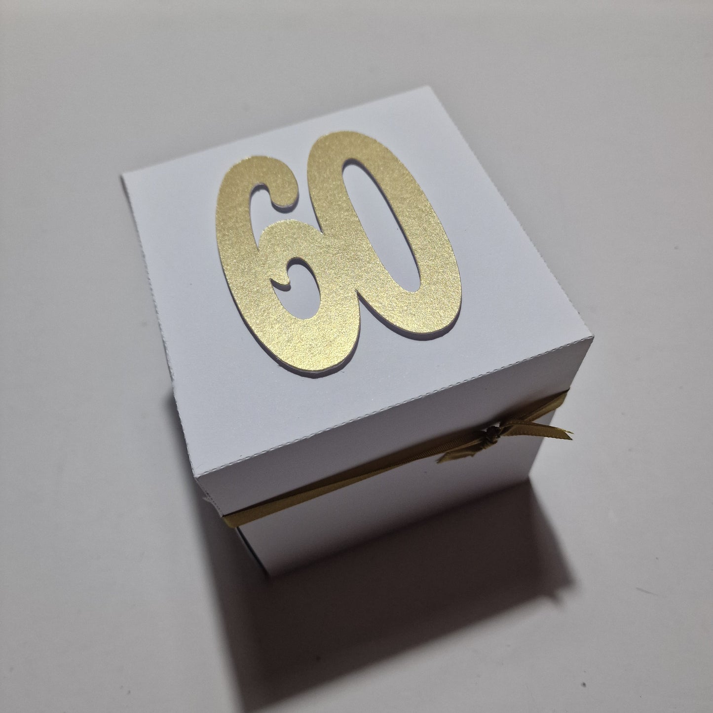 New York - Black & Gold - Surprise Special Occasion | Celebration Trip Reveal Explosion Box featuring gold numbers on a sleek white box, designed for a surprise trip reveal with themed panels and a Statue of Liberty centerpiece.