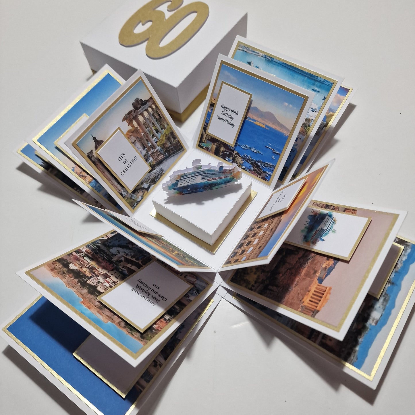 Close-up of New York - Black & Gold - Surprise Special Occasion | Celebration Trip Reveal Explosion Box, featuring a paper cutout ship and a freestanding Statue of Liberty on a white surface.