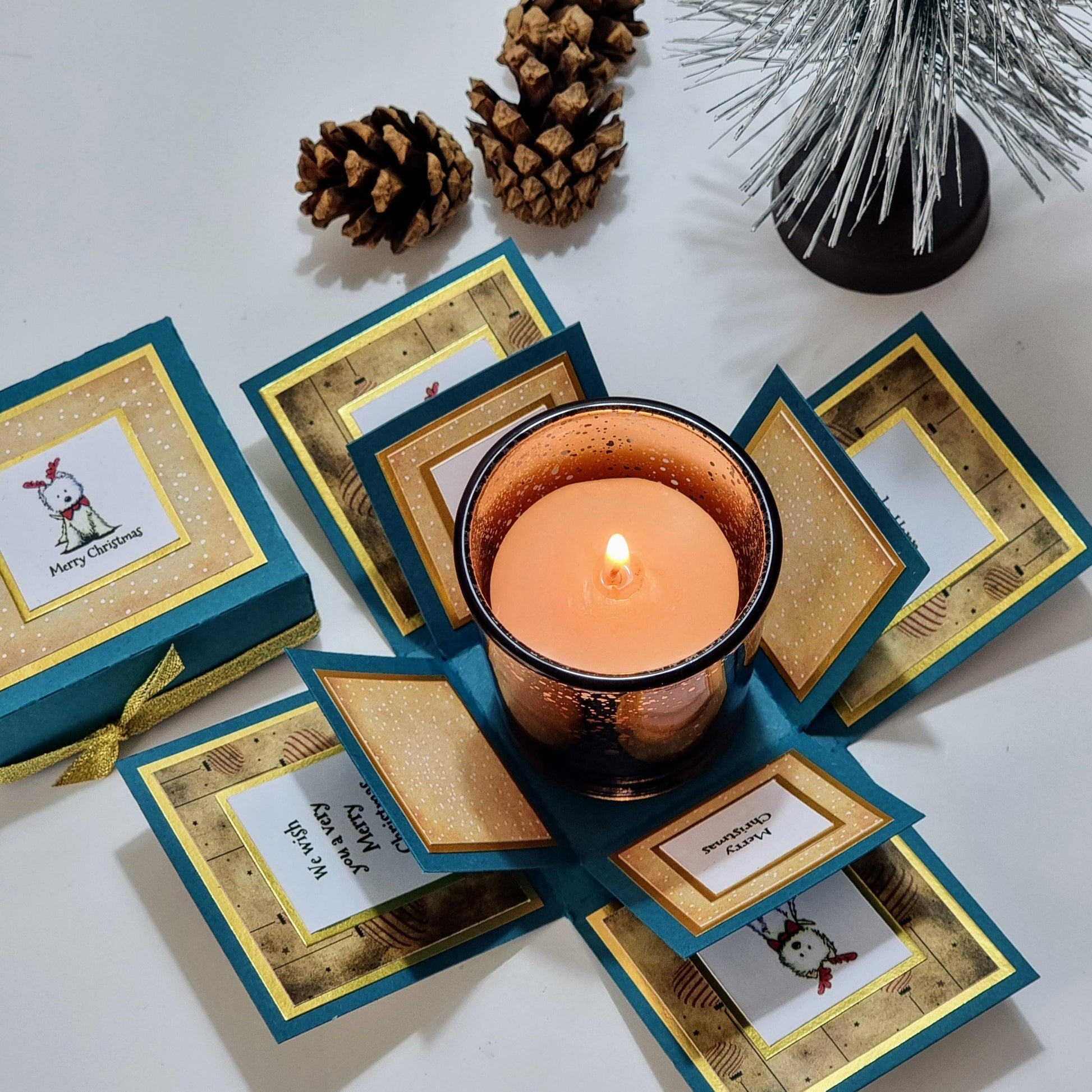Lou Lou The Westie Christmas Candle Box features a teal box with a festive West Highland Terrier design, containing a removable votive candleholder and Christmas-scented candle.