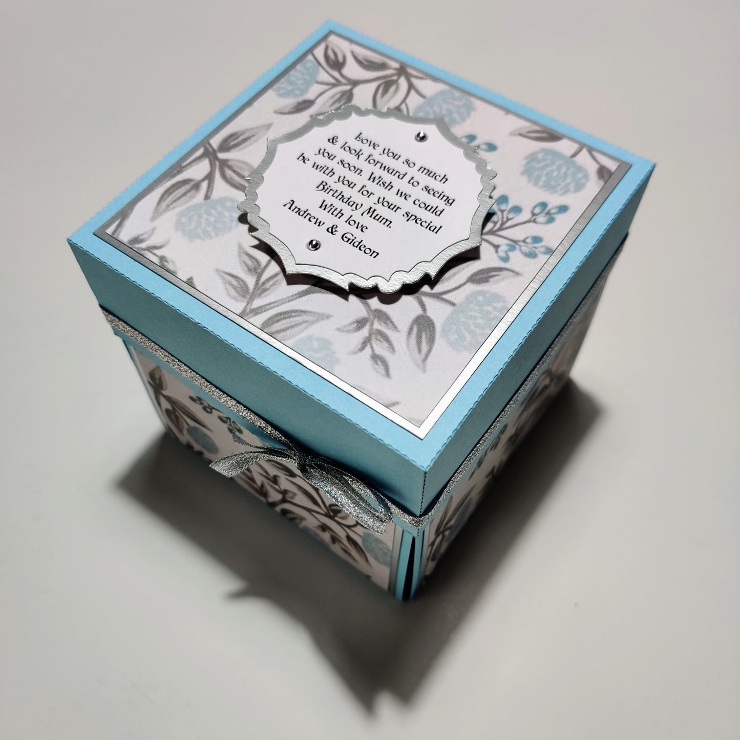 Pastel Blue Florals Birthday Celebration Pop-Open Box Card featuring intricate floral designs, perfect for creating memorable birthday surprises.