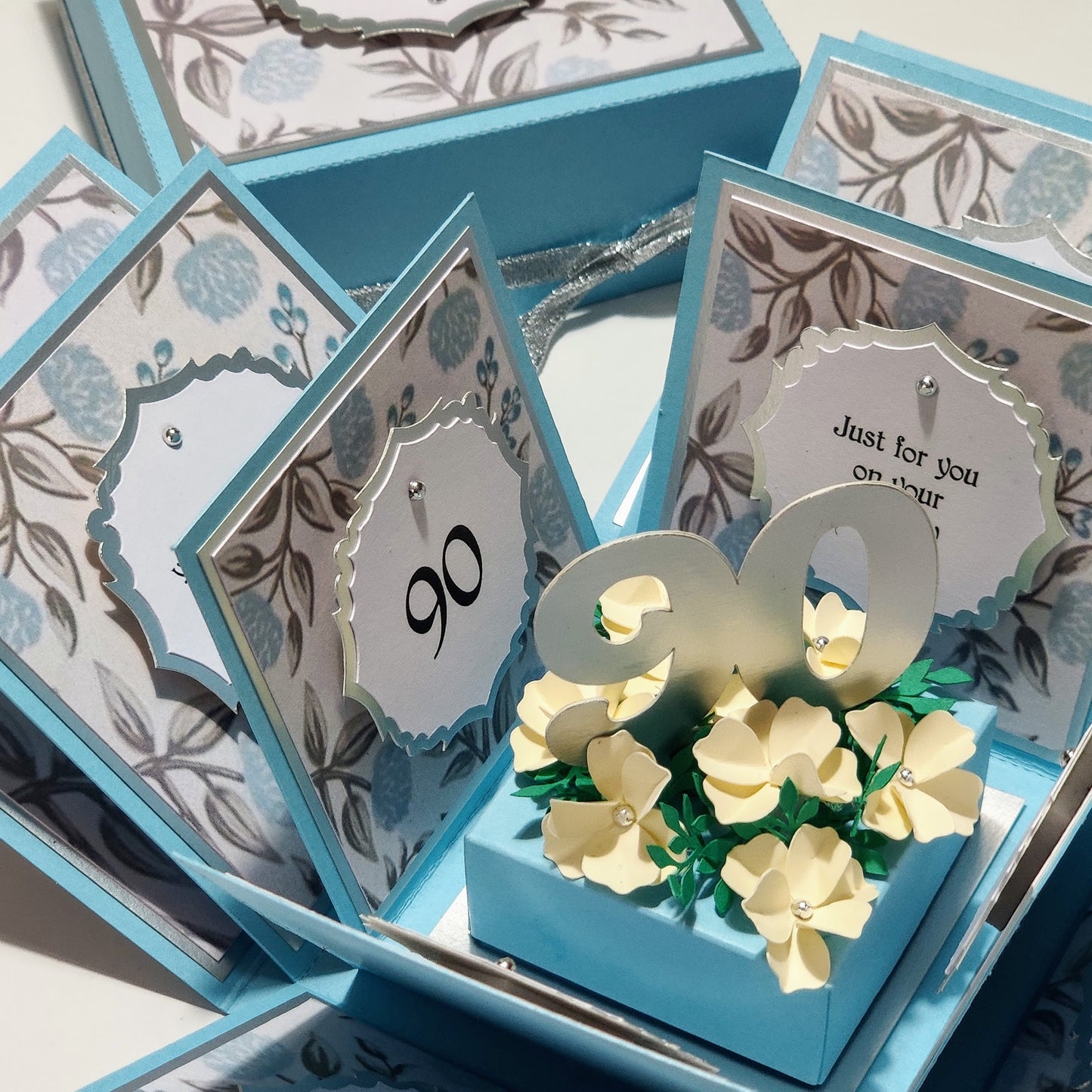 Pastel Blue Florals Birthday Celebration Pop-Open Box Card featuring intricate floral patterns designed to surprise and delight upon opening. Ideal for birthdays, this card offers an engaging and festive presentation.