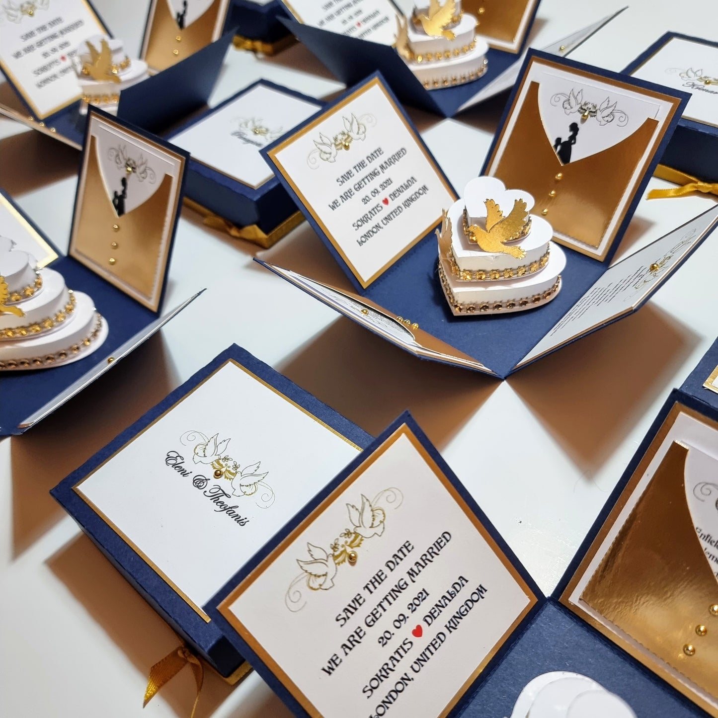 Navy Blue & Gold~ Hearts & Doves Exploding Wedding Invitation Boxes featuring elegant cards, a heart-shaped cake with gold bird decorations, and sophisticated navy and gold invitation details.