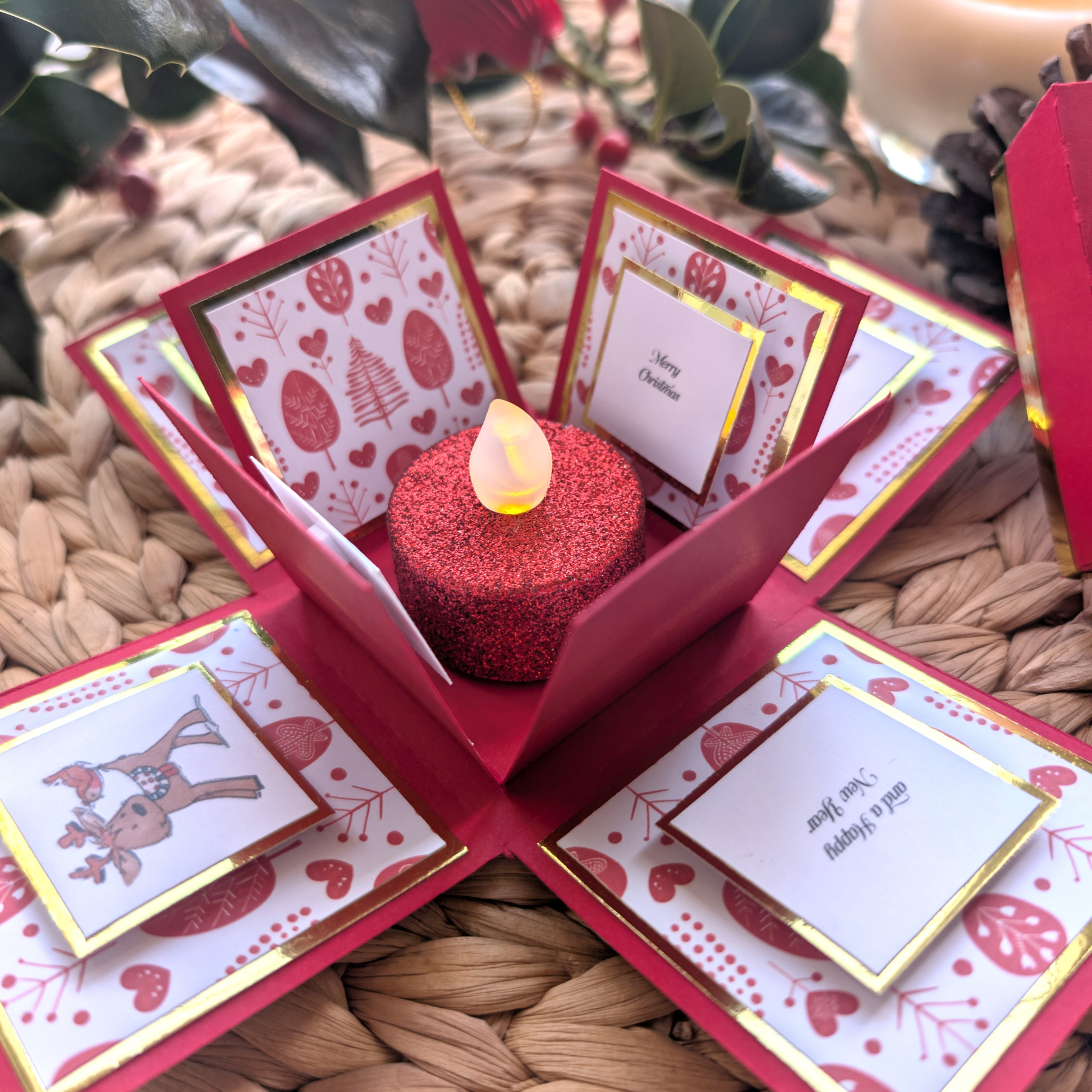 Rudy the Reindeer Exploding Christmas Box Card features festive flaps with holiday greetings and a glittery LED candle centerpiece, creating a charming holiday surprise.