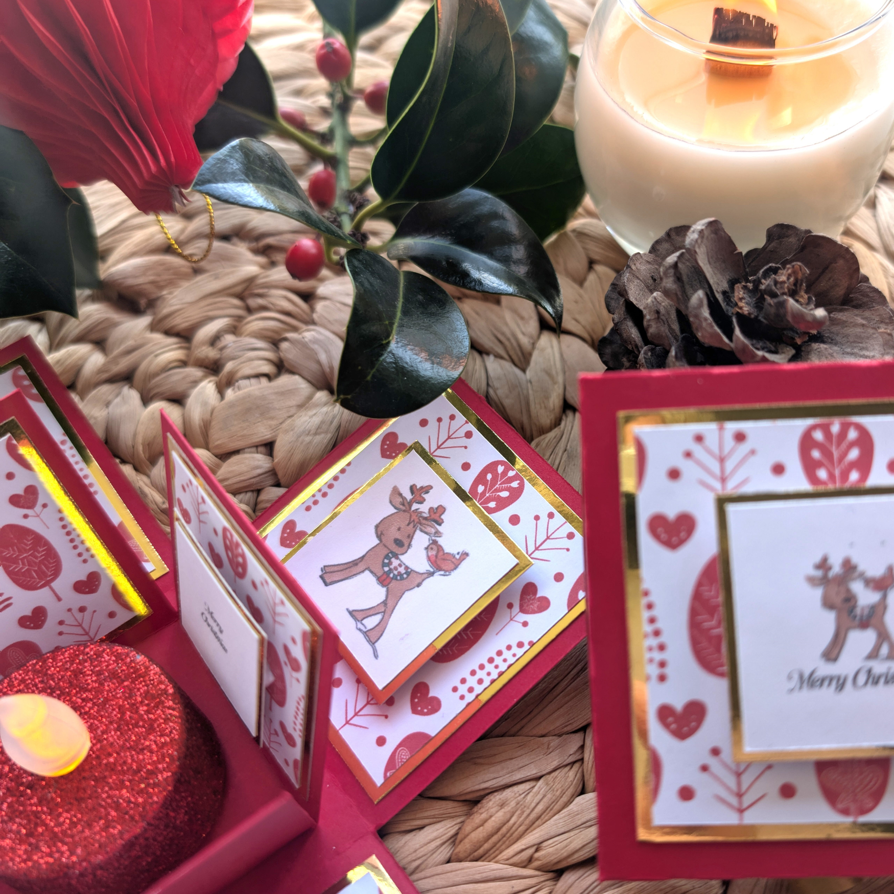 Rudy the Reindeer Exploding Christmas Box Card showcases a festive pop-open design with gold trim, featuring a reindeer and bird motif, and includes a glittery tealight candle, perfect for holiday cheer.