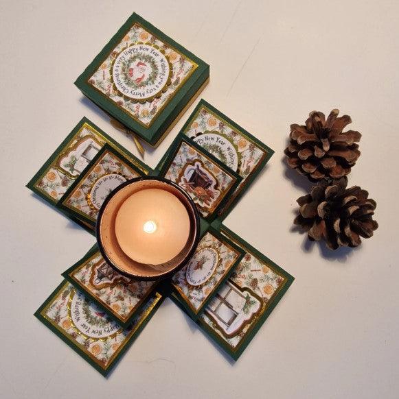 Vintage styled Christmas Candle Box with a removable votive candle and holder, surrounded by pine cones. The box features elegant gold accents and vintage Christmas embellishments.