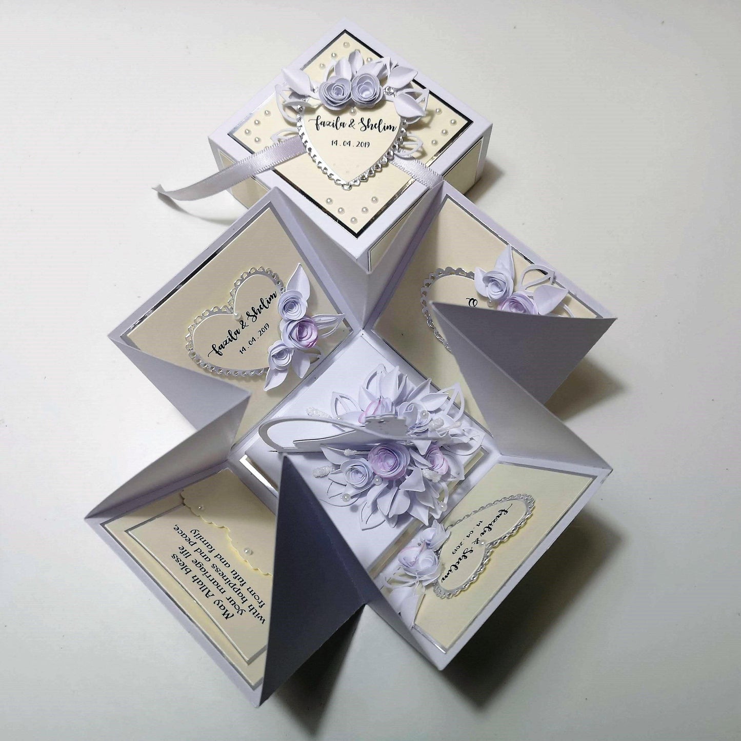 Exploding Wedding Keepsake Box - Gift - Card featuring floral designs, a heart-shaped card, and a white ribbon, perfect for holding travelers cheques or cash with personalized wedding details.