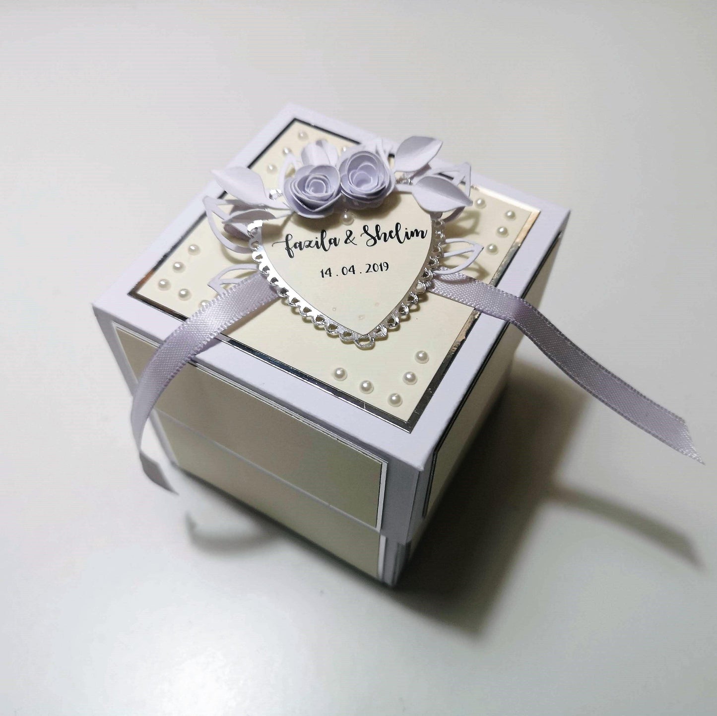 Exploding Wedding Keepsake Box - Gift - Card featuring a heart design, ribbon accents, and a pocket for cash or cheques, adorned with a Bride & Groom silhouette under an arbour with white roses.