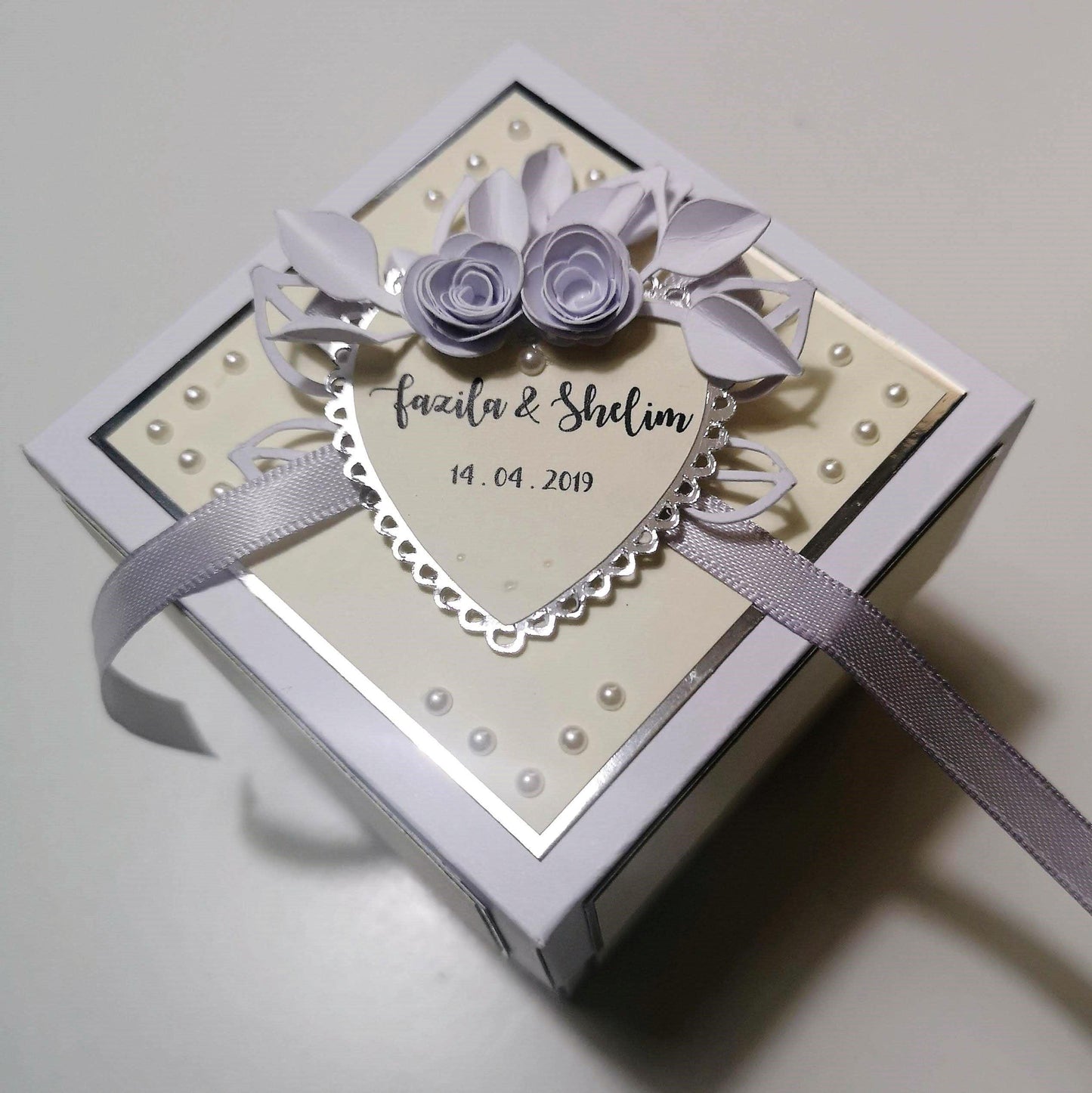 Exploding Wedding Keepsake Box - Gift - Card featuring a heart and floral decorations, with a ribbon, designed to hold a personalized message, names, and wedding date, adorned with white roses.