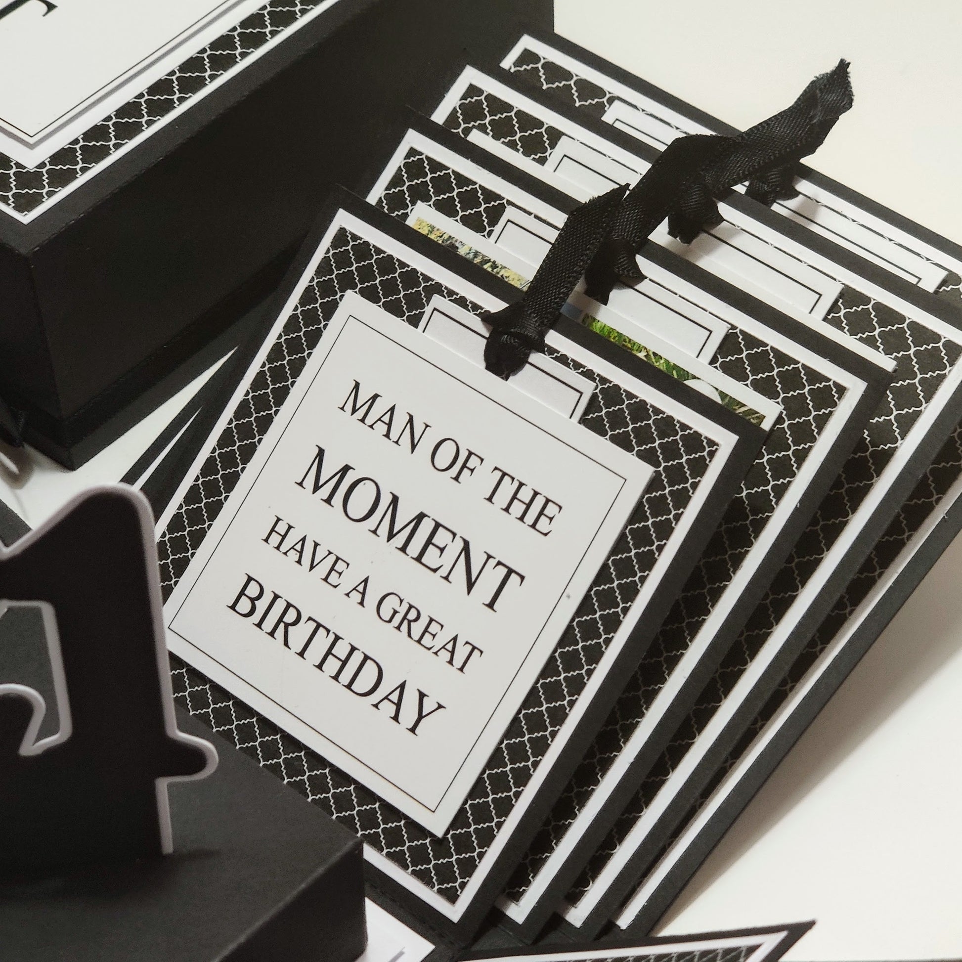 Exploding Memory Photo Box - Surprise Gift - Keepsake Album Box features a monochrome geometric pattern, unfolds into a cross-shaped layout with ribbon-secured photo slots and a central compartment for mementoes.