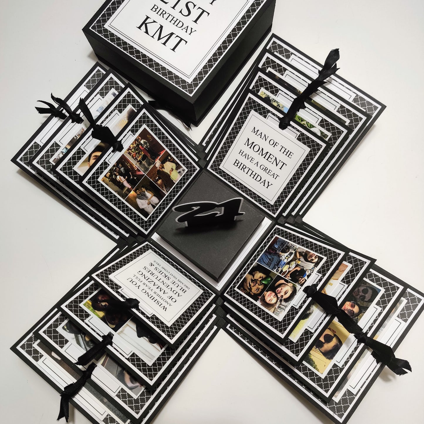 Exploding Memory Photo Box - Surprise Gift - Keepsake Album Box features a monochrome geometric pattern with bold lettering, layered compartments, ribbon-secured photo slots, and a special center compartment for mementoes.