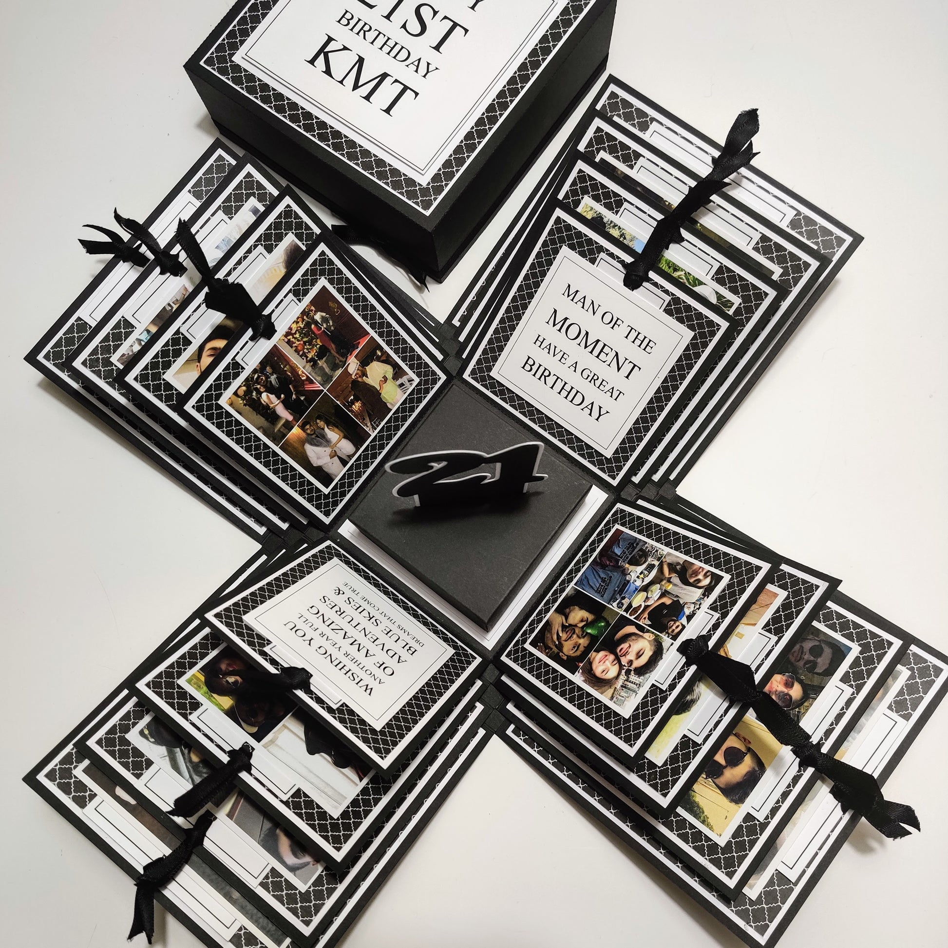 Exploding Memory Photo Box - Surprise Gift - Keepsake Album Box features a monochrome geometric pattern with bold lettering, layered compartments, ribbon-secured photo slots, and a special center compartment for mementoes.