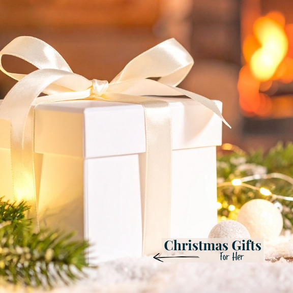 White gift box with a bow on a blurred festive background with text 'Christmas Gifts for Her'.