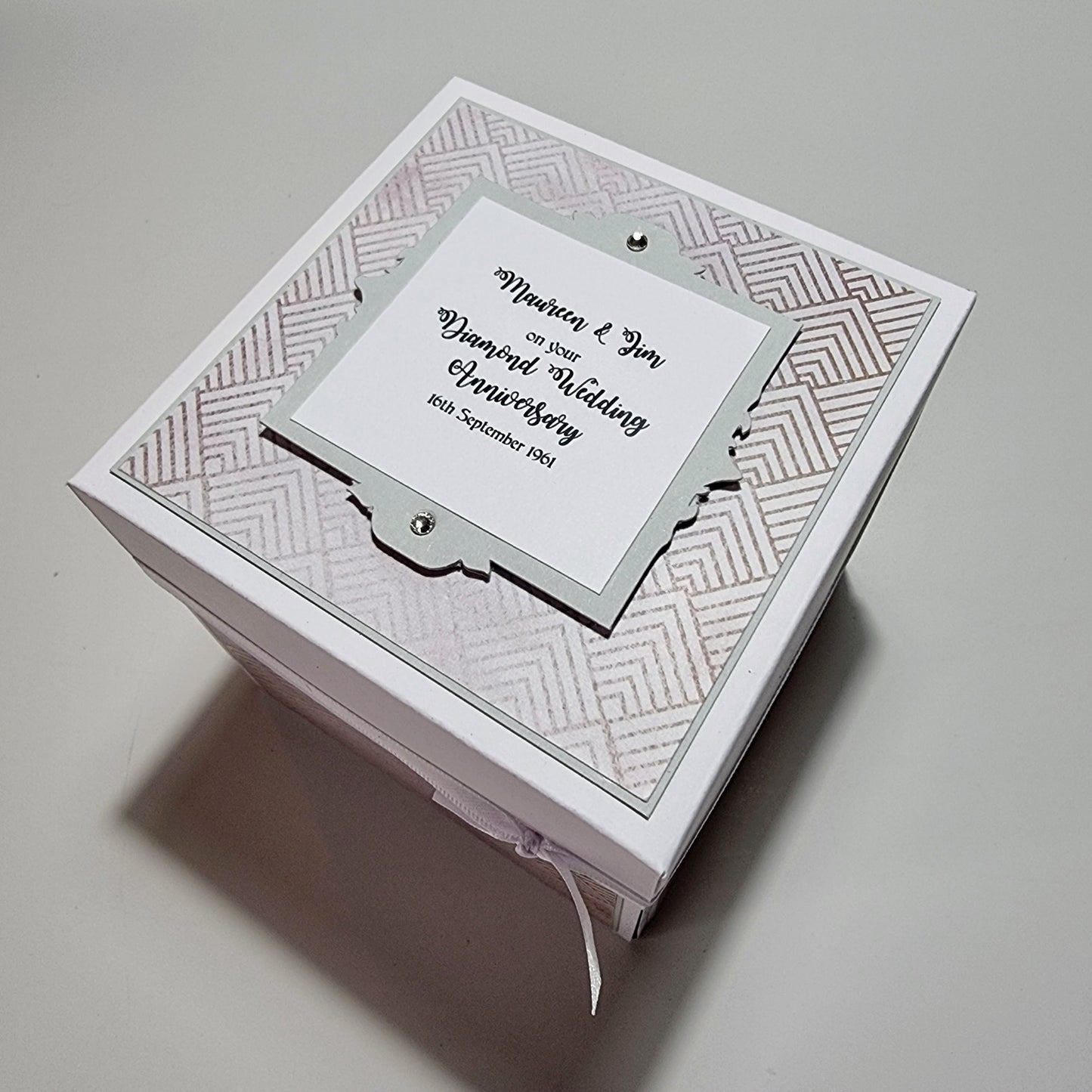 Diamond Wedding Anniversary Exploding Box; a white box with a personalized label, unfolds to reveal sentimental messages and diamond-inspired accents, offering a unique keepsake for celebrating 60 years together.