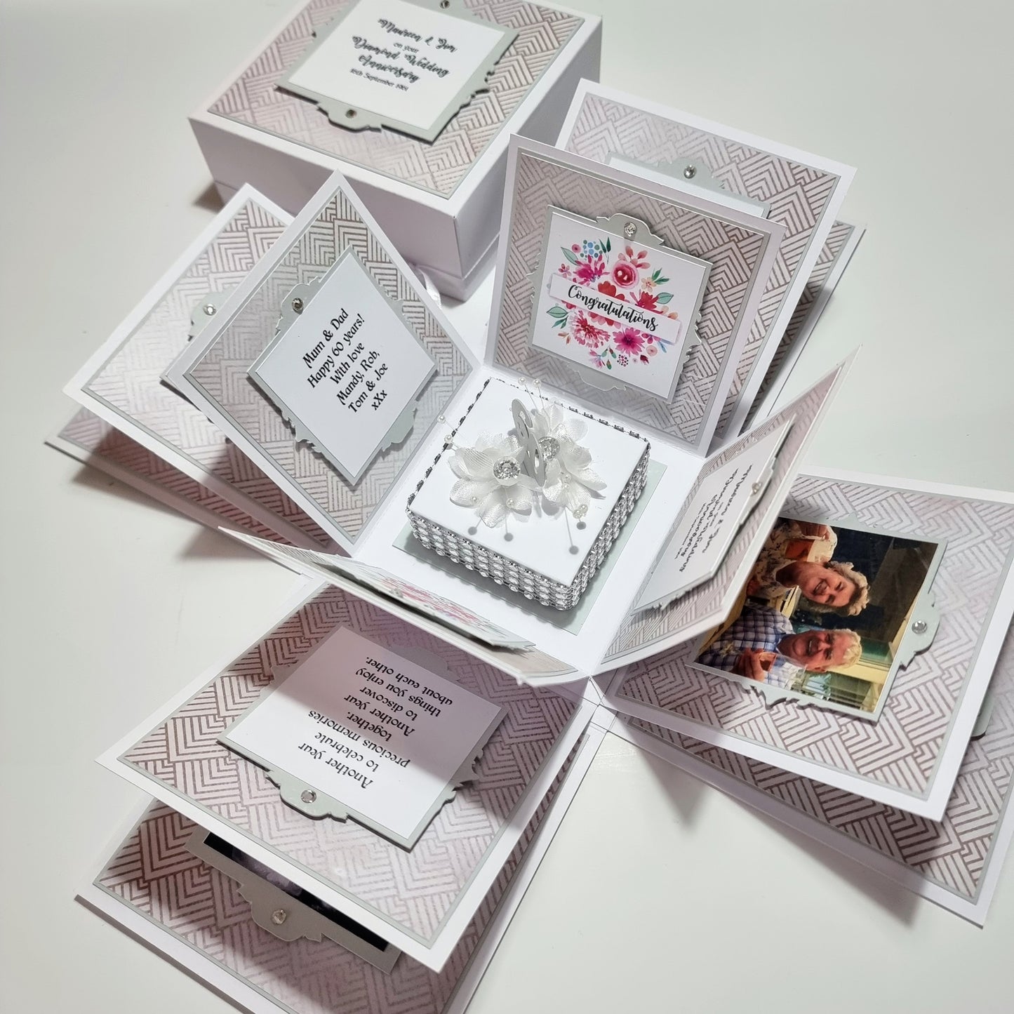 Diamond Wedding Anniversary Exploding Box adorned with floral and rhinestone accents opens to reveal personalized messages and photos, perfect for a 60th-anniversary celebration.