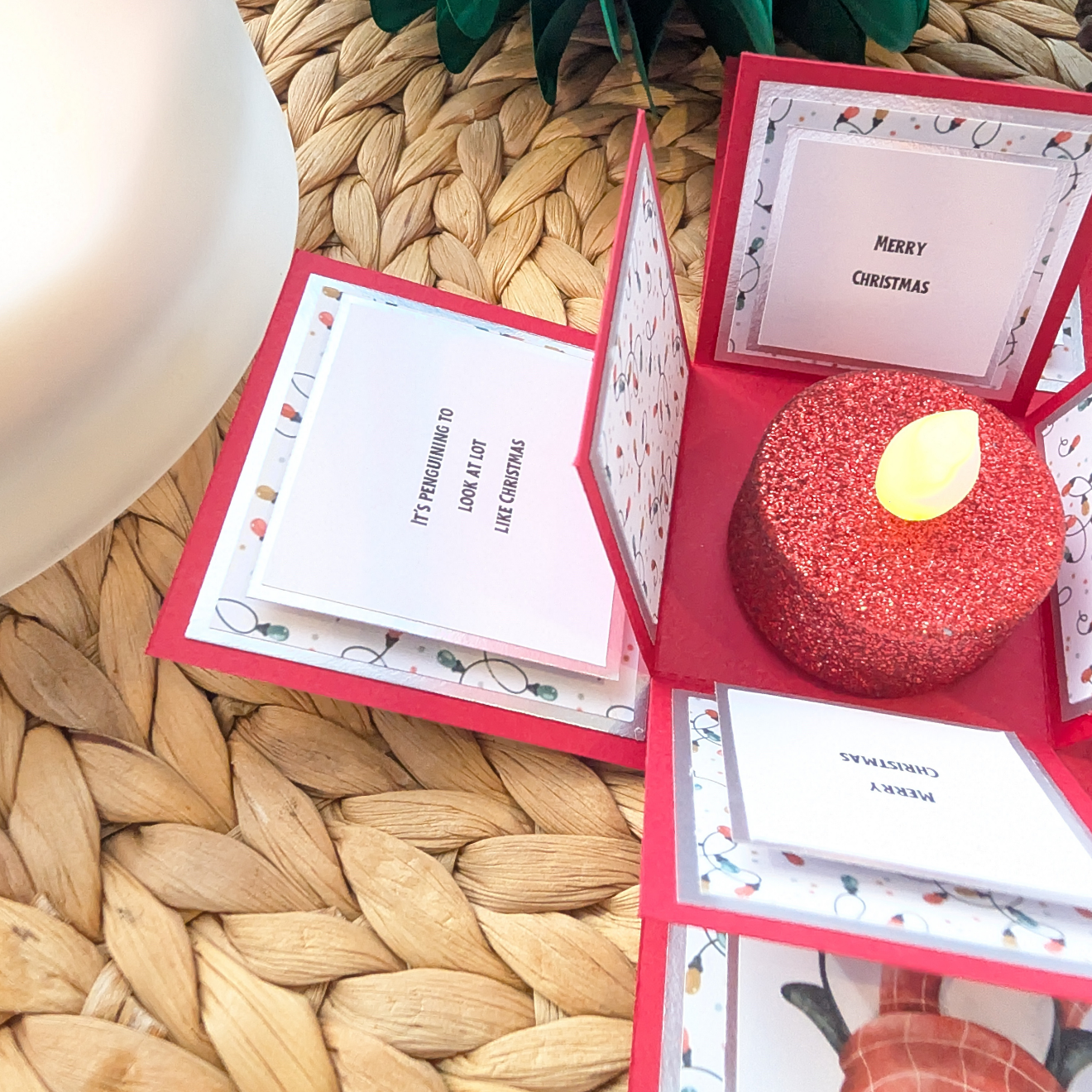 Frosty The Penguin Christmas Box Card features an explosion-style design with penguin-themed panels and holiday greetings, centered around a glittery red LED tea light, creating a festive pop-up surprise.