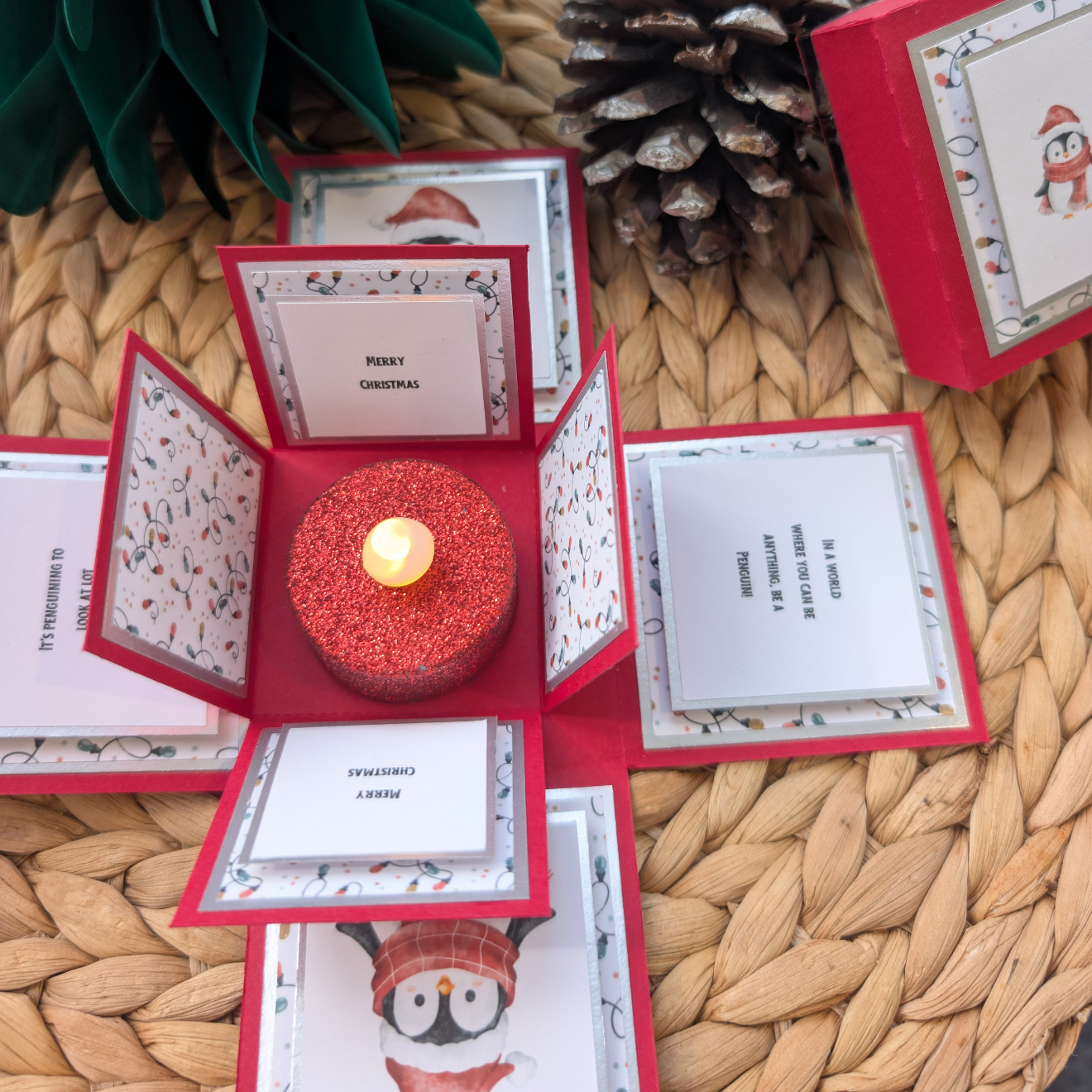 Frosty The Penguin Christmas Box Card – Festive Holiday Greeting with Pop-Up Design. Features patterned panels, holiday messages, and a glittery LED tealight centerpiece, perfect for a heartwarming Christmas surprise.