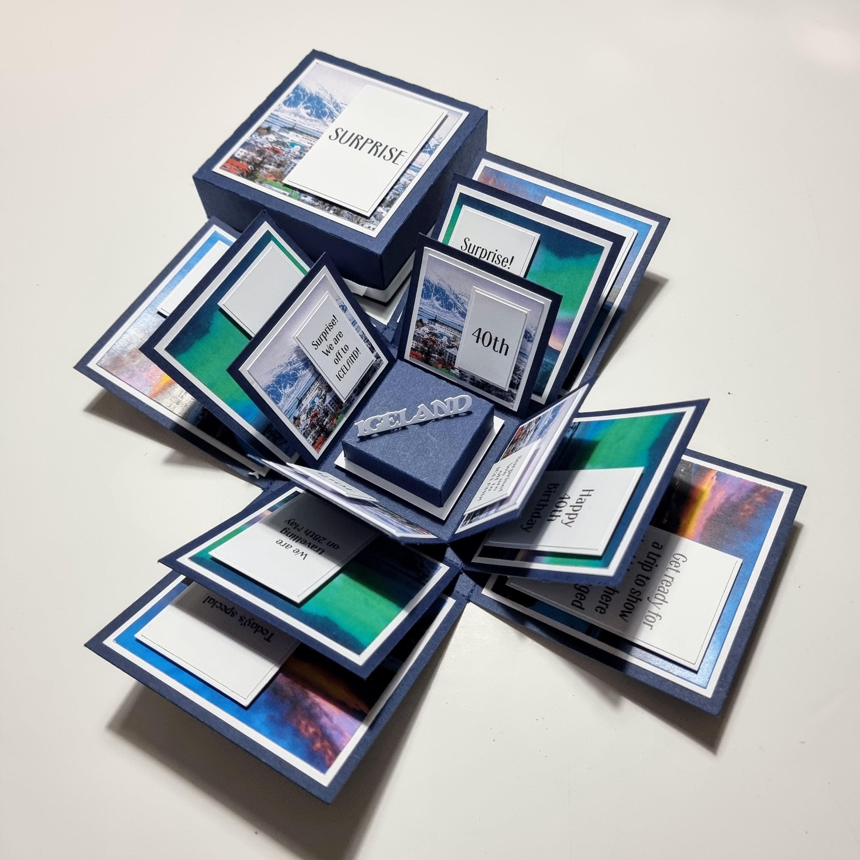 Exploding Occasions Box - Trip Reveal ICELAND: A folded paper box featuring intricate landscape and verse panels, designed to unveil a surprise Icelandic trip, complete with customizable details for a special occasion.
