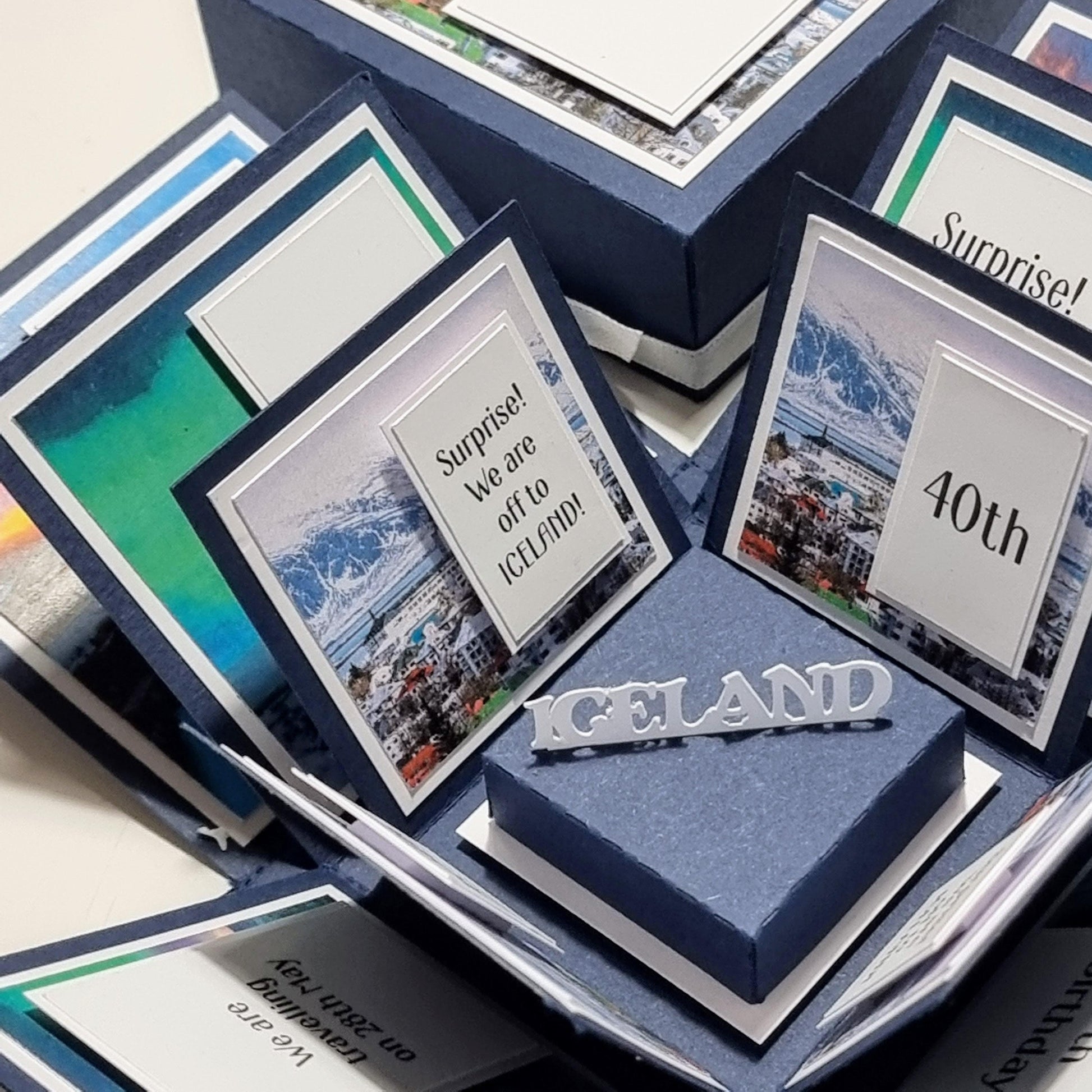 Exploding Occasions Box - Trip Reveal ICELAND: A blue box featuring Iceland-themed images and text, designed to unveil surprise trip details with landscape and verse panels.