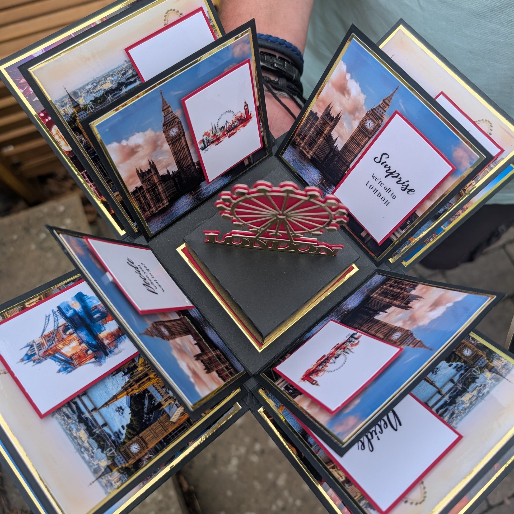 London - Special Occasion | Celebration Trip Reveal Explosion Box: An open pop-up card featuring London landmarks with a central London Eye motif and Surprise – we’re off to LONDON message, perfect for surprise trip announcements.