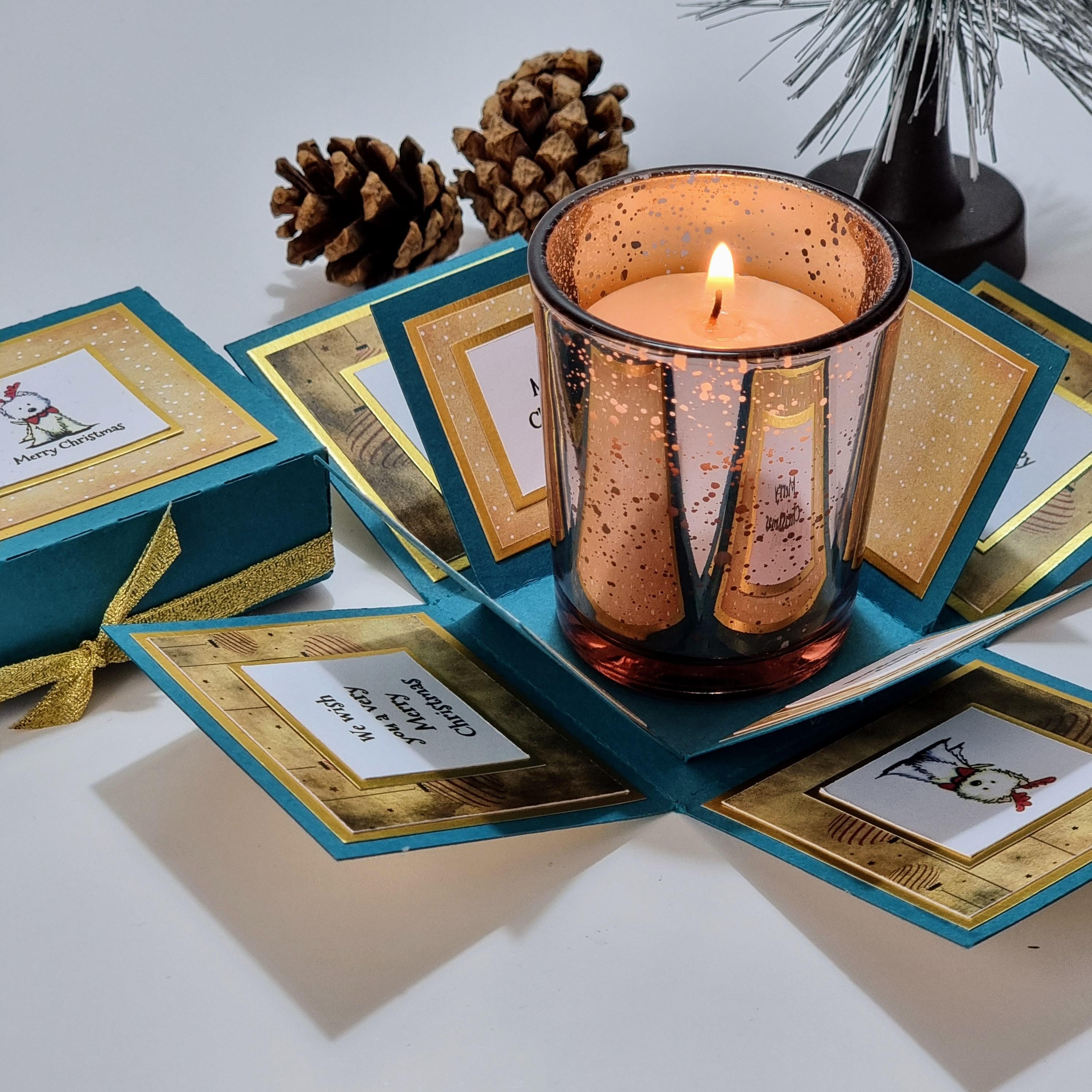 Lou Lou The Westie Christmas Candle Box features a teal box with a West Highland Terrier design, containing a votive candleholder and a Christmas scented candle, perfect for festive gifting.