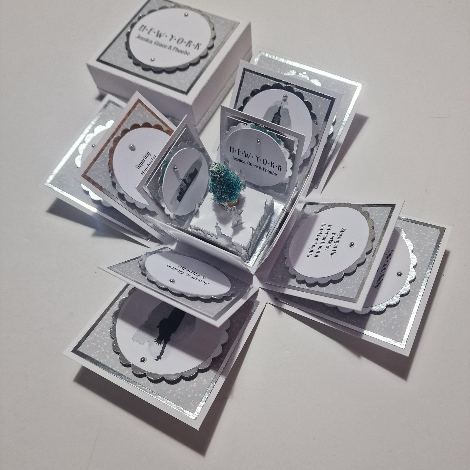 Close-up of the New York - Black & Gold Surprise Special Occasion Explosion Box, featuring a white sign with black text as part of its intricate, handcrafted design celebrating NYC's charm.