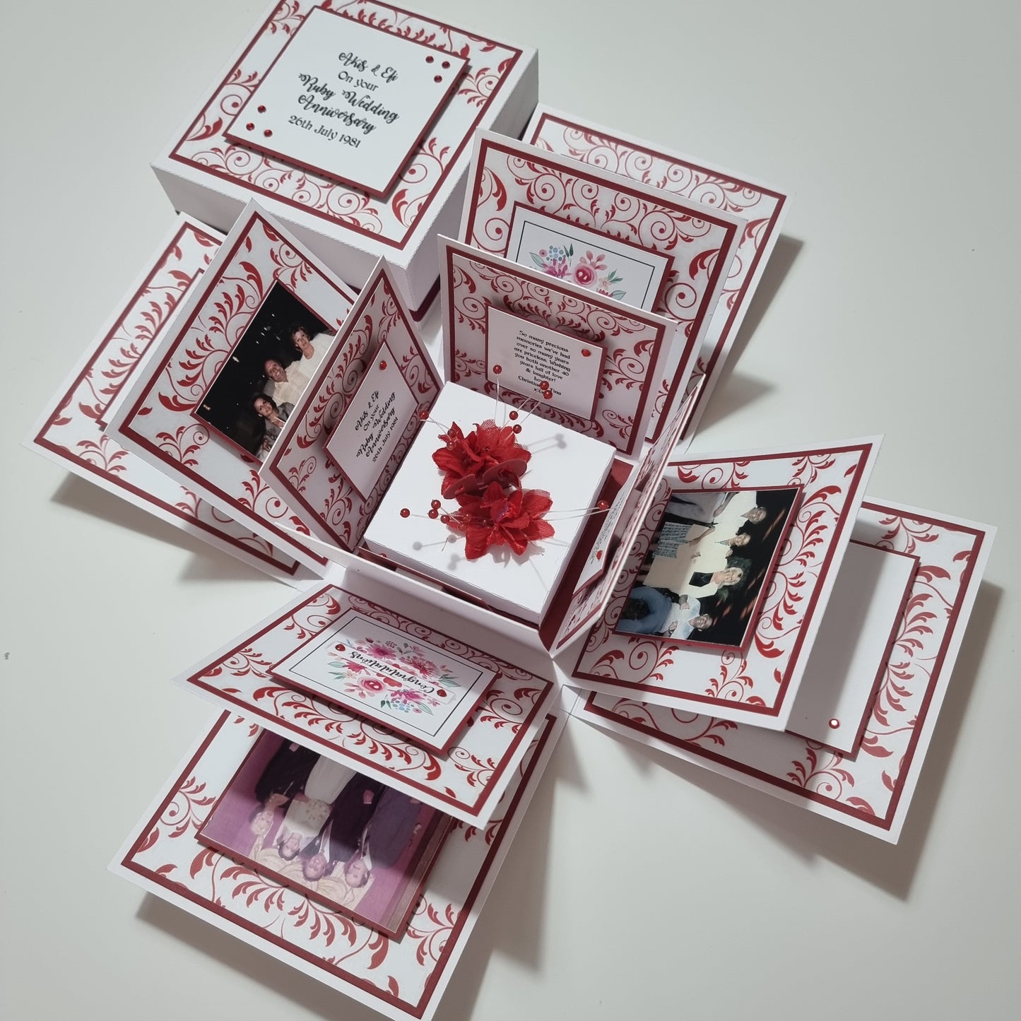 Ruby Wedding Anniversary Exploding Box featuring a white base with ruby-red accents, adorned with pictures, red flowers, and beads, perfect for celebrating a 40th wedding anniversary.