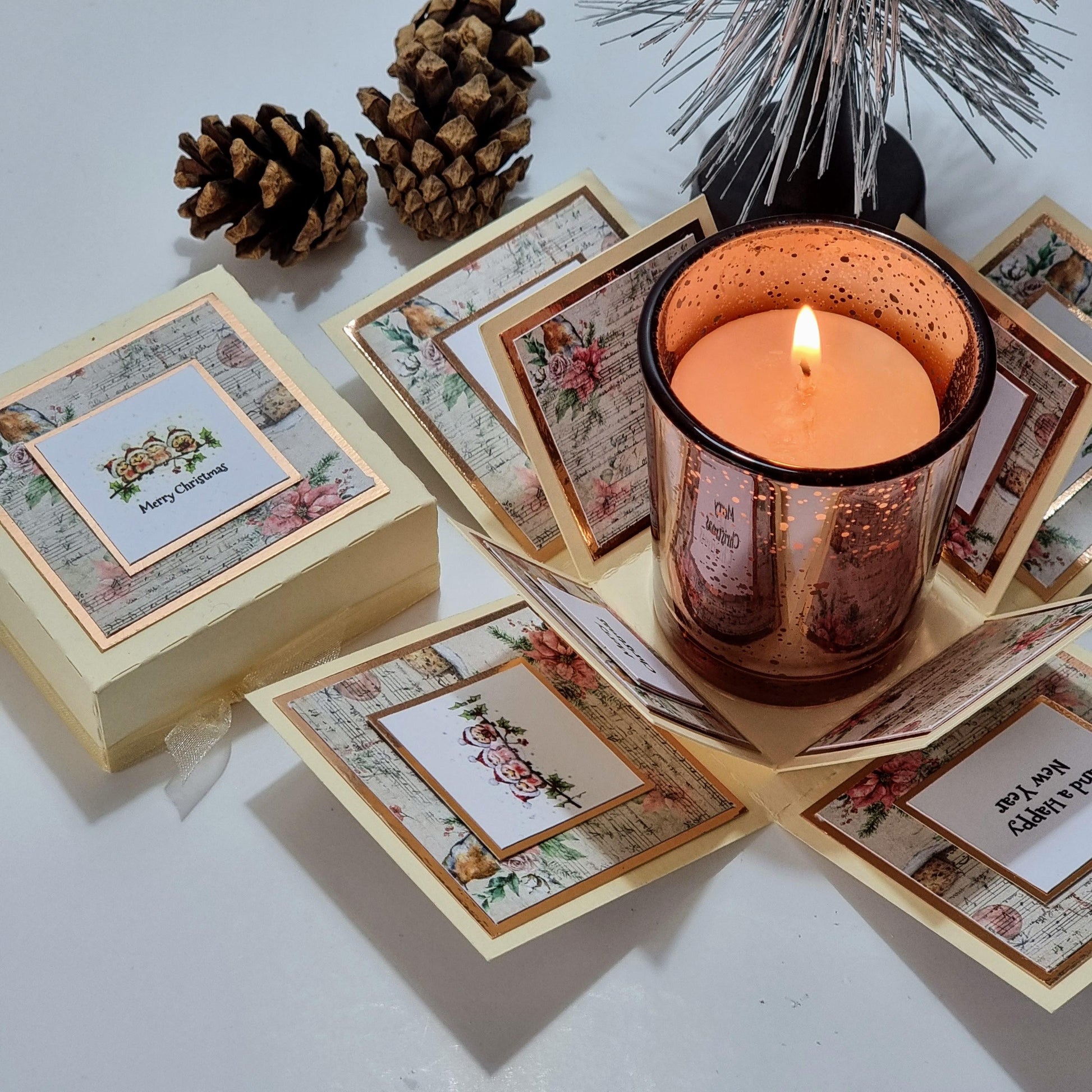 Rocking Robin Christmas Candle Box with a Christmas-scented candle in a glass holder, featuring a festive robin design and a removable votive candleholder within a clotted cream cardstock box.
