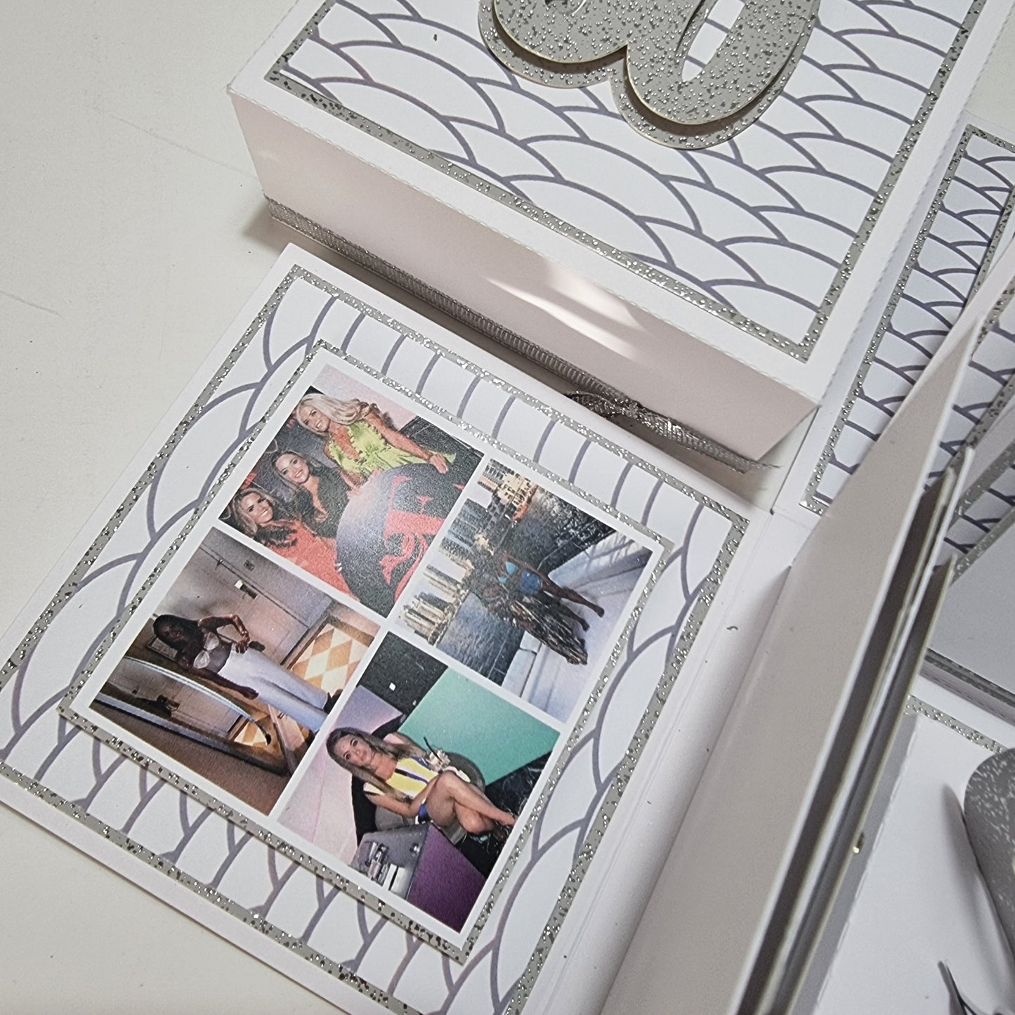 Exploding Memory Photo Box - Silver Scalloped Waves, featuring elegant silver accents. Unfolds to reveal photo panels and a 30 centerpiece with a champagne bottle cutout, ideal for milestone celebrations.