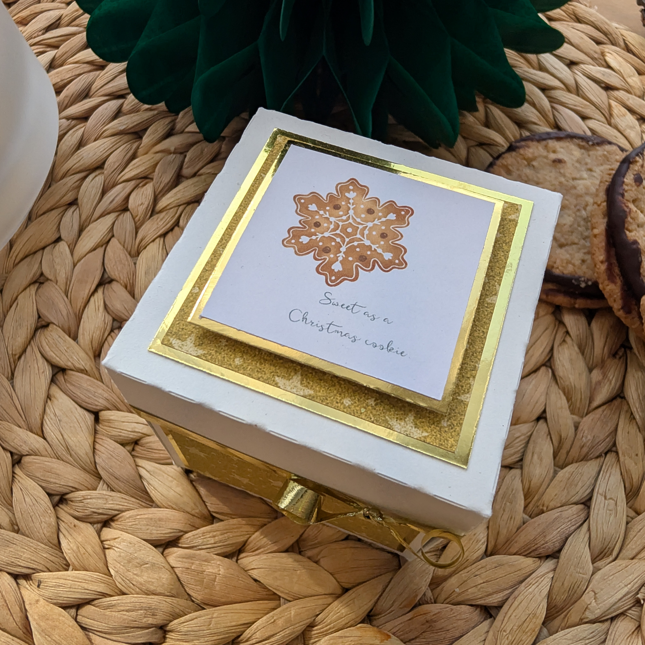Exploding Christmas Box Card with Shortbread Recipe sits on a placemat, featuring festive design and cookies. Includes a snowflake card reading “Sweet as a Christmas cookie,” promising a delightful holiday surprise.