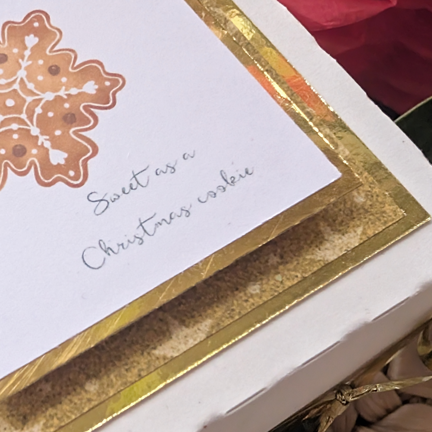Exploding Christmas Box Card with Shortbread Recipe features a white gift box with gold trim, topped with a gingerbread snowflake card saying “Sweet as a Christmas cookie,” nestled in a wicker basket.