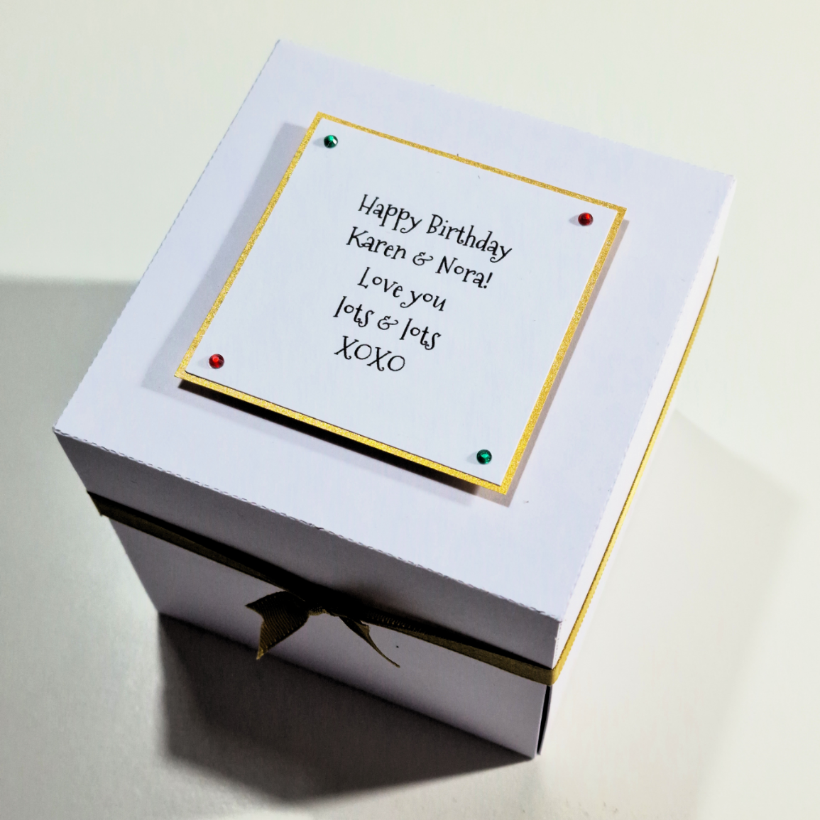 Close-up of the Christmas Markets Exploding Trip Reveal Gift Box featuring a white box with a handwritten card, highlighting the unique holiday surprise element.