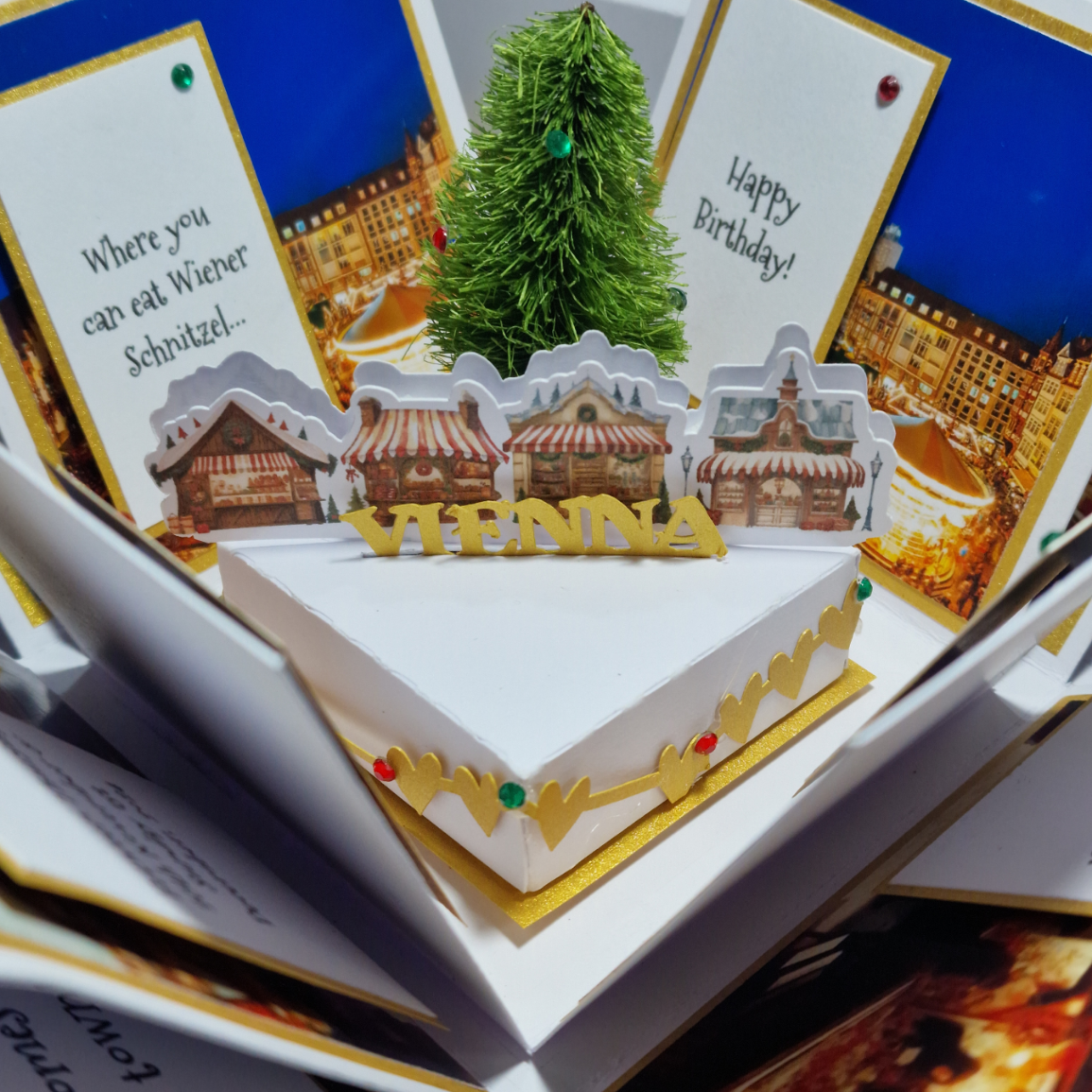Christmas Markets Exploding Trip Reveal Gift Box featuring a close-up of a card and a small artificial Christmas tree, embodying a unique twist on the traditional holiday experience.