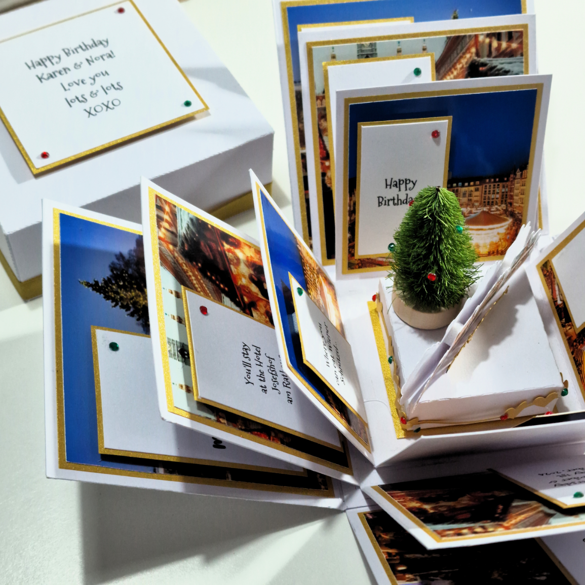 Close-up of the Christmas Markets Exploding Trip Reveal Gift Box, featuring a card, a picture, and a small artificial Christmas tree, encapsulating the magic and excitement of holiday market surprises.