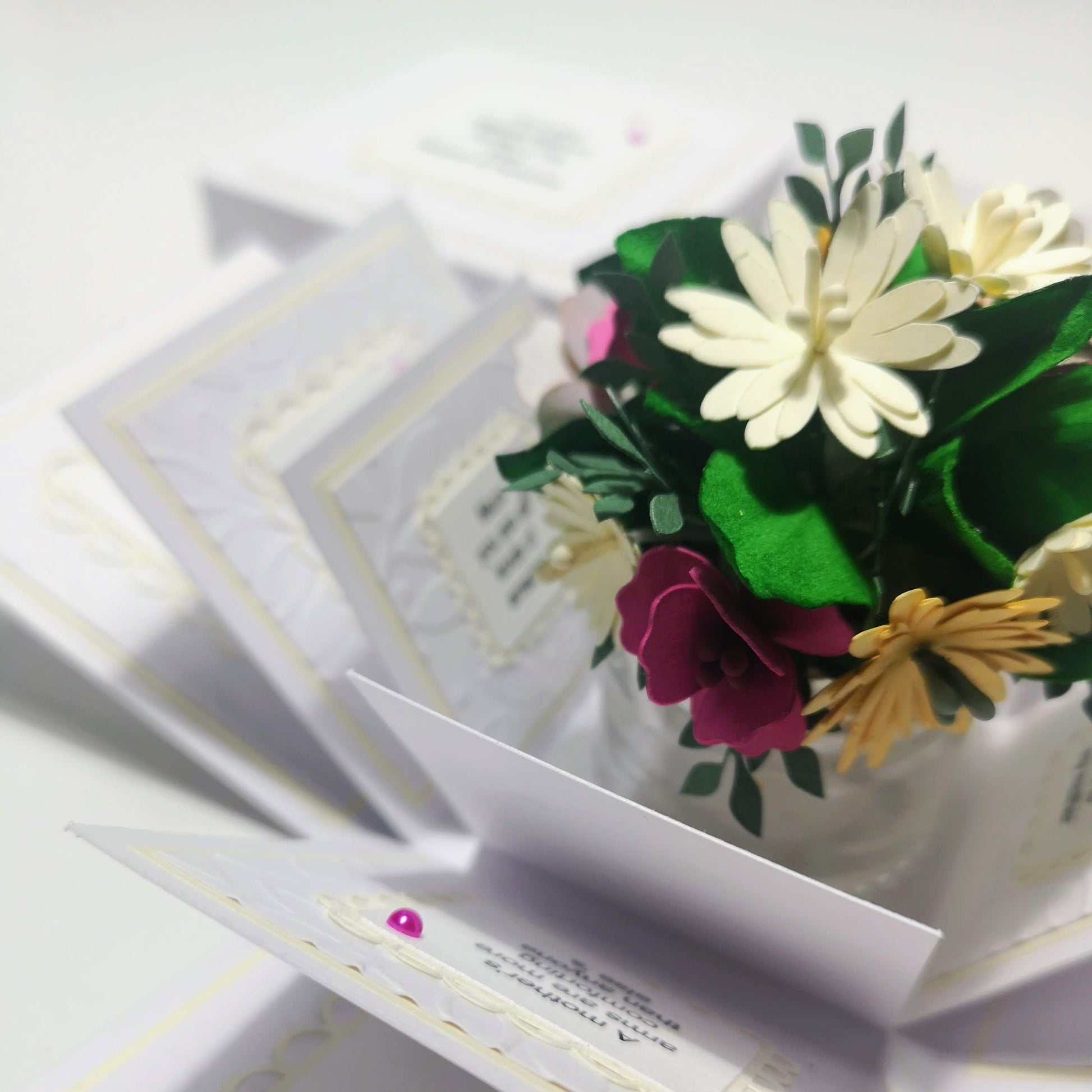 Mother's Day Forever Flower Bouquet Explosion Gift showcases a paper flower bouquet with white and pink petals, green leaves, and personalized messages, elegantly displayed in a pop-open celebration gift box.