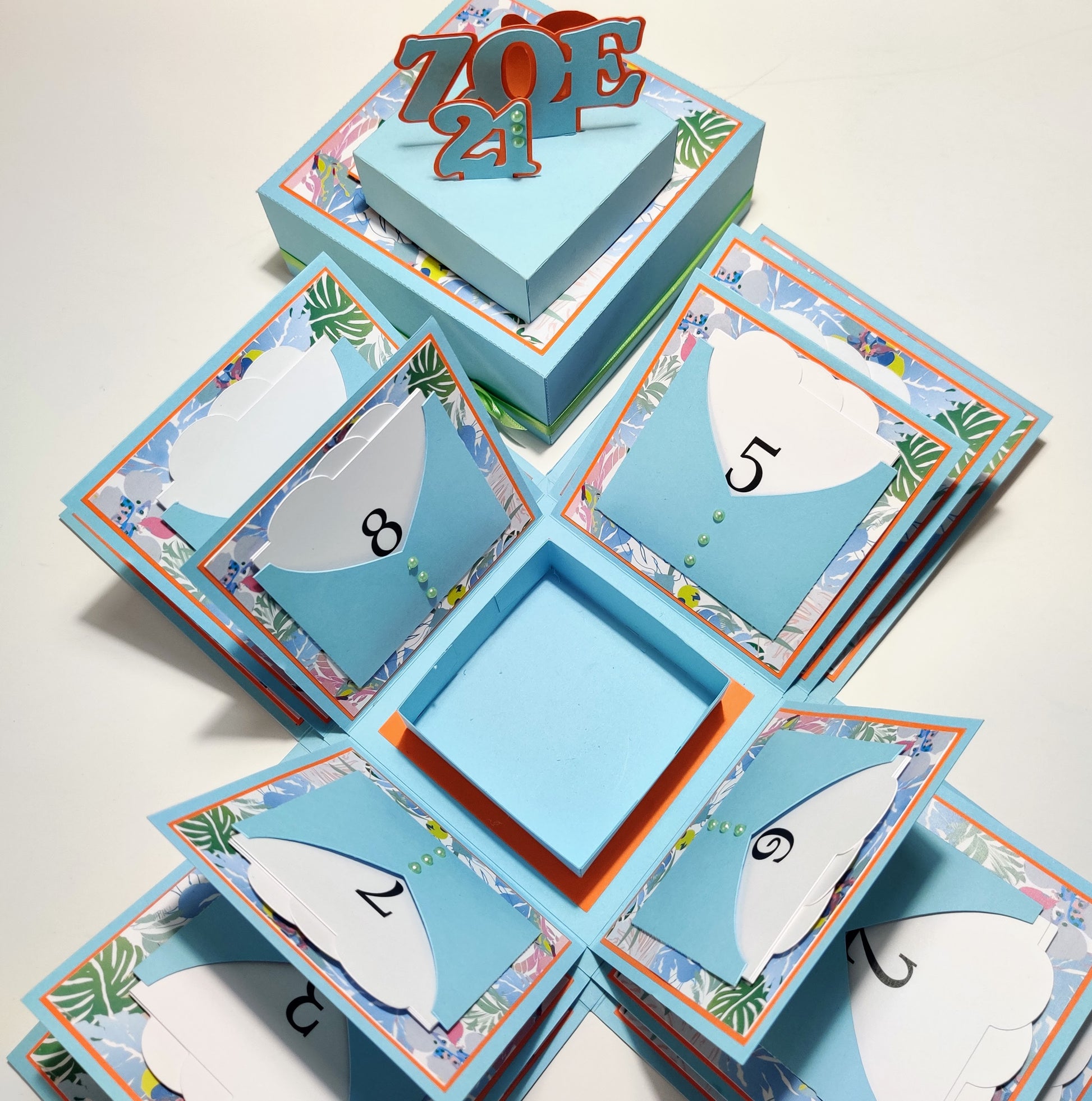 Exploding Memory Photo Box featuring multiple layers with flip albums and pockets, designed as a surprise gift or keepsake album. Available in five sizes, customizable with various design options.