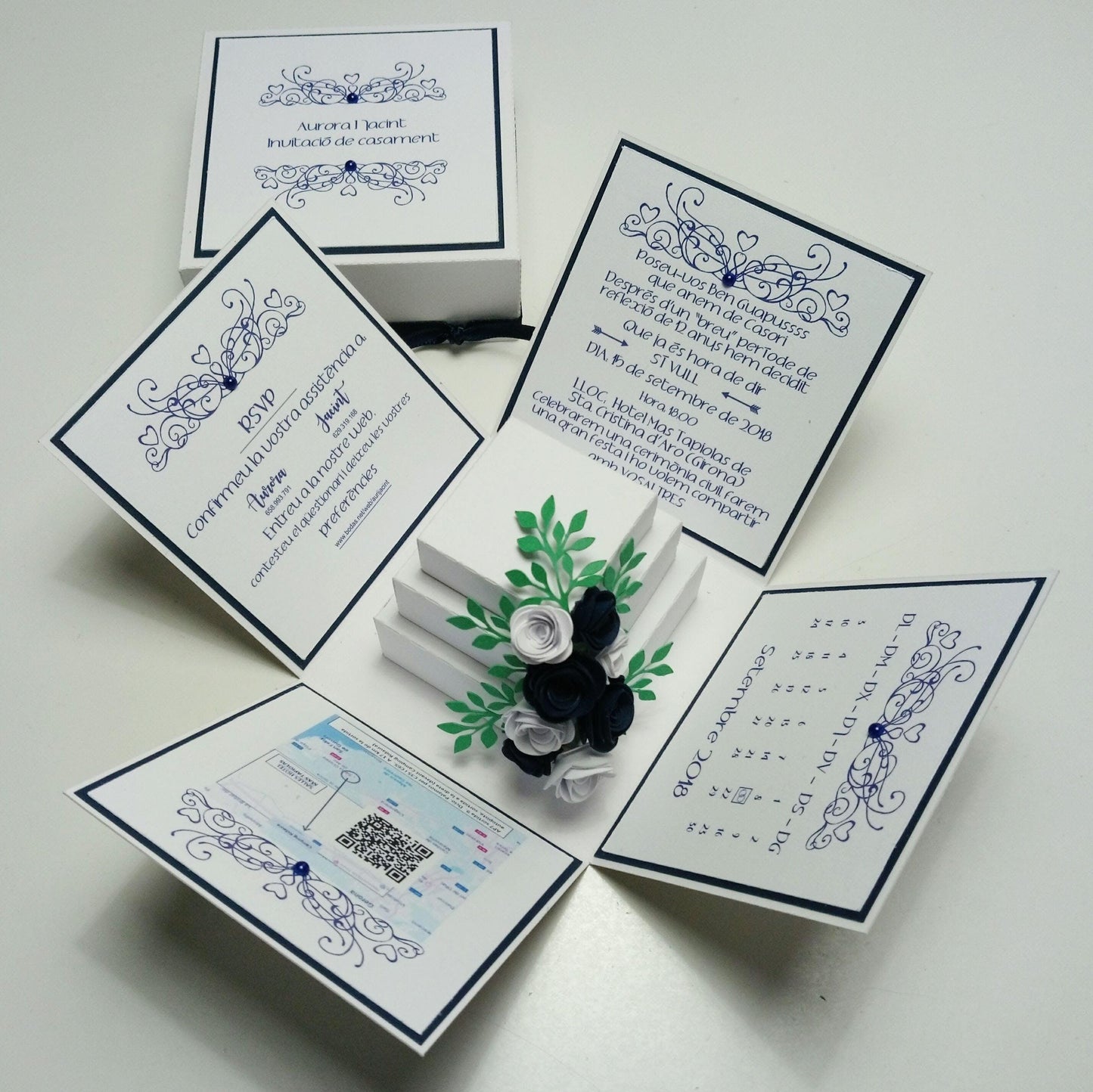 Exploding Wedding Invitation Box featuring a three-tier decorated cake, surrounded by panels for invite details. Includes a QR code card. Luxurious bespoke invites for weddings, personalized with names and venue.